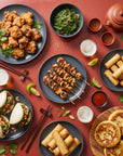Asian Street Food SeriosFood - masa bogata pe blat metal rosu cu karaage, yakitori, gua bao, hotteok, spring rolls, salata wakame, sosuri si bere