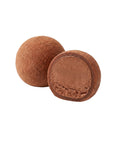 Două mochi mini cu ciocolată, unul secționat, pe fundal alb
