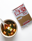 Supă miso aka servită cu lingură renge, lângă punga de pastă miso roșu