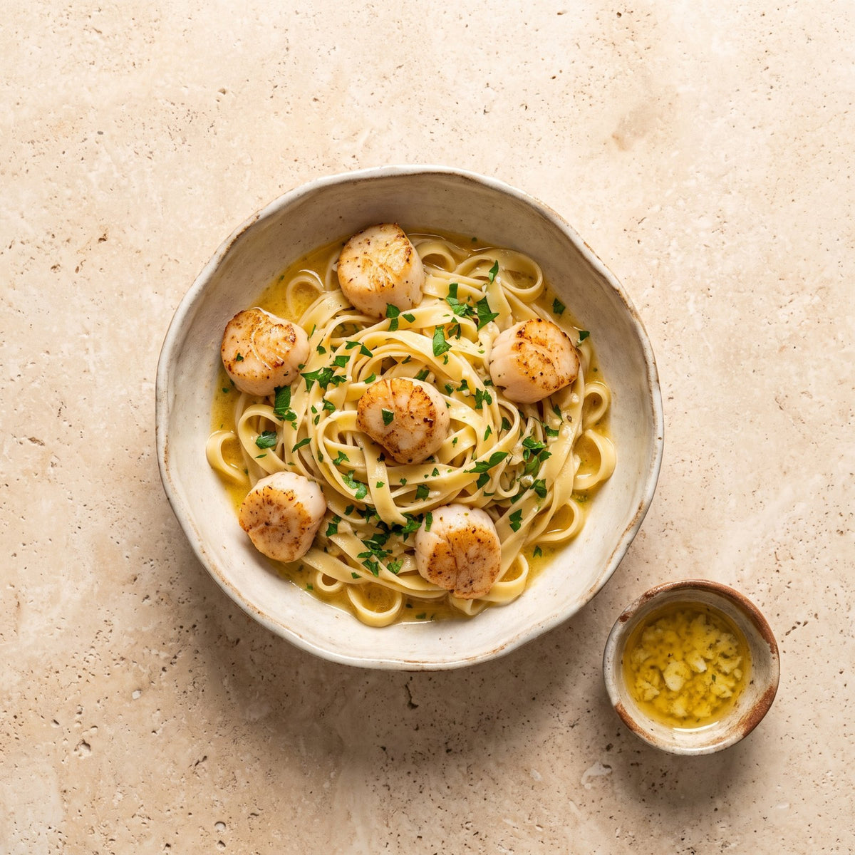 Scoici Saint-Jacques rumenite peste linguine cu unt de usturoi și lămâie