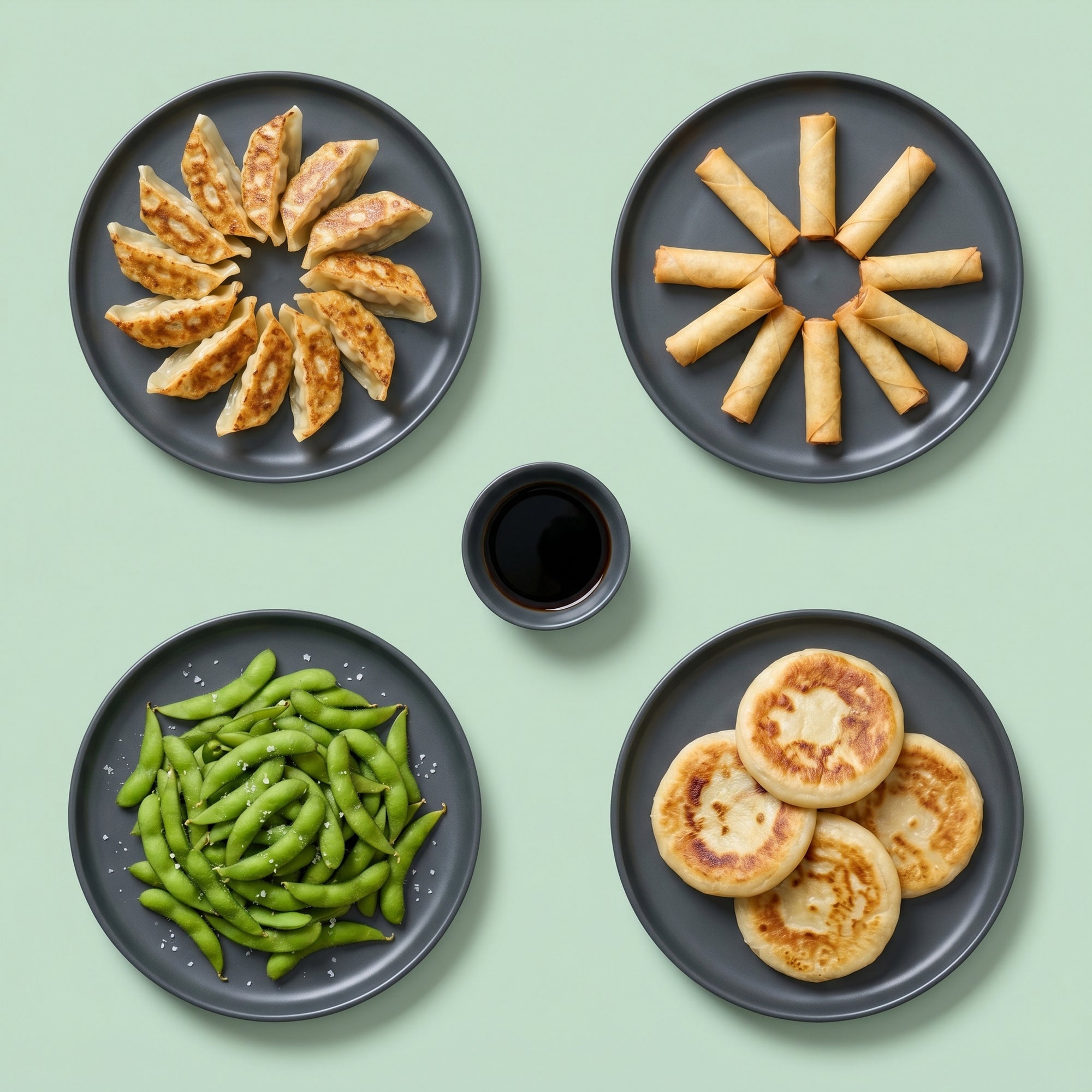 Vegan Asia SeriosFood - selectie vegana asiatica vedere de sus: gyoza vegetariene, mini spring rolls, edamame cu sare, hotteok corean si sos de soia