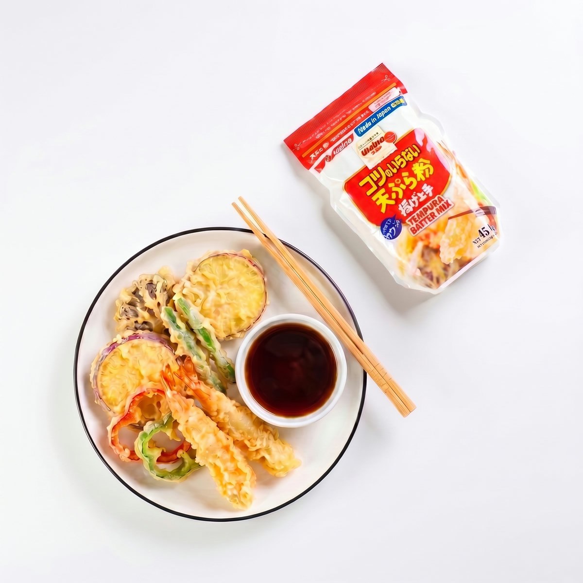 Tempura crocantă servită pe farfurie cu sos, lângă punga de făină tempura