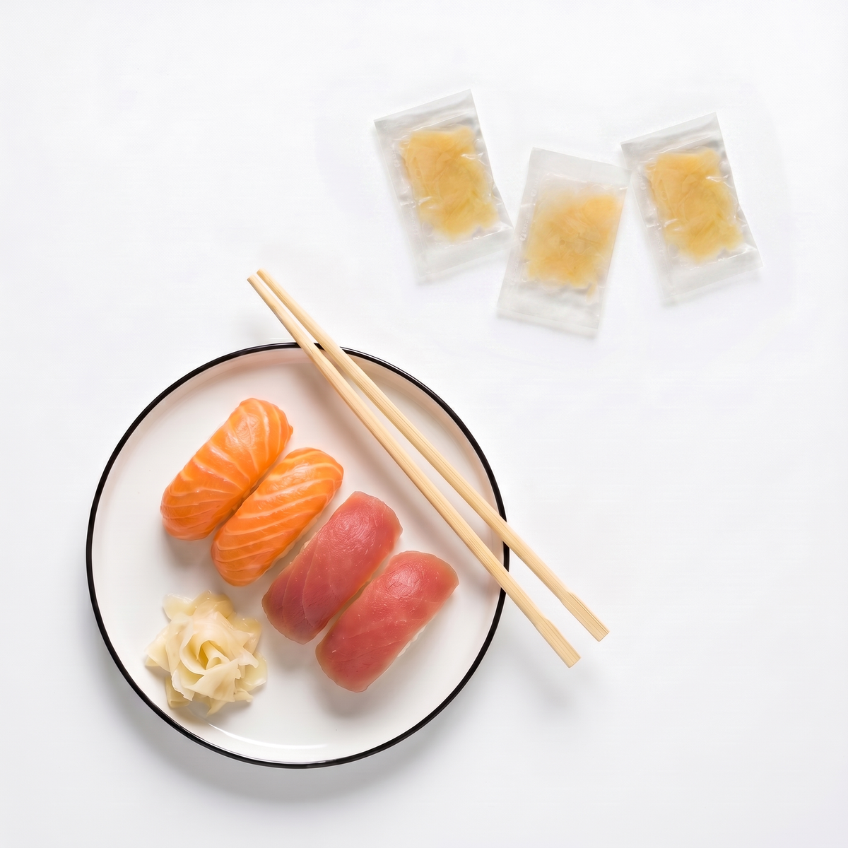 Gari alb servit lângă nigiri sushi, cu plicurile individuale de ghimbir murat
